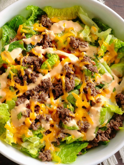 A bowl of salad with cheese and dressing.