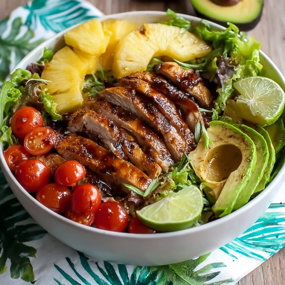 A bowl of chicken salad with pineapple, lime, and avocado.