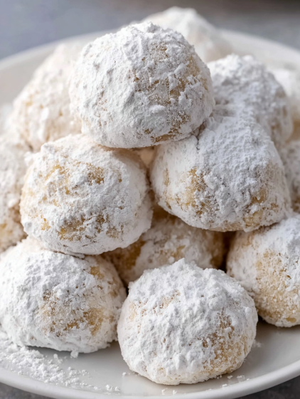 A plate of powdered sugar donuts.