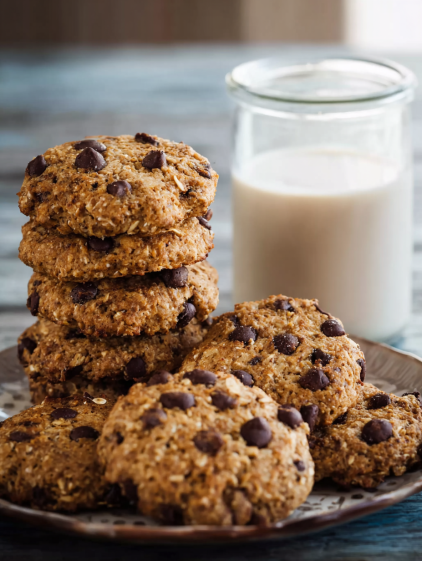 A stack of chocolate chip cookies with milk.