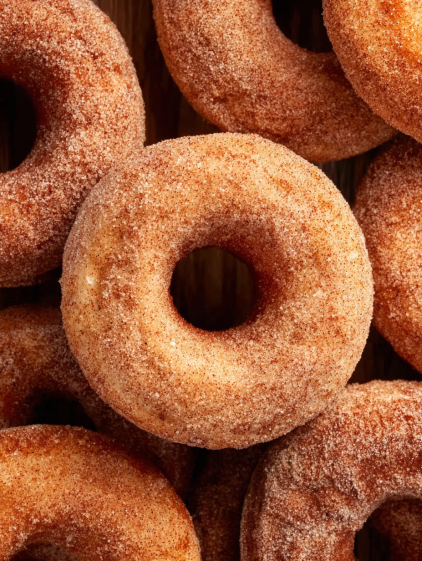A pile of donuts with sugar on top.