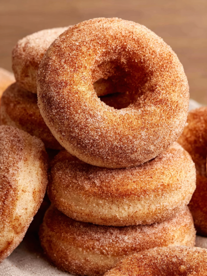 A stack of donuts with sugar on top.
