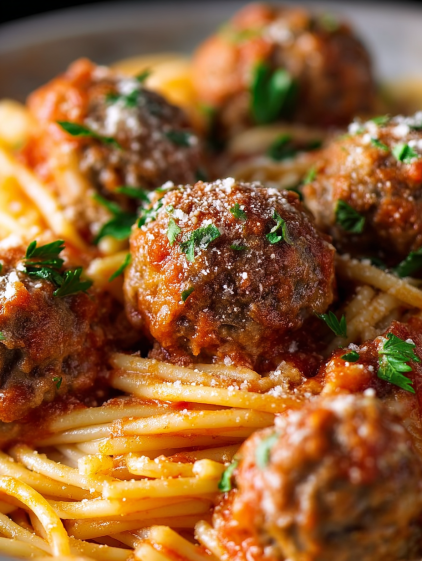 A plate of spaghetti with meatballs and sauce.