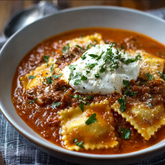 A bowl of creamy lasagna soup with pasta and white sauce.