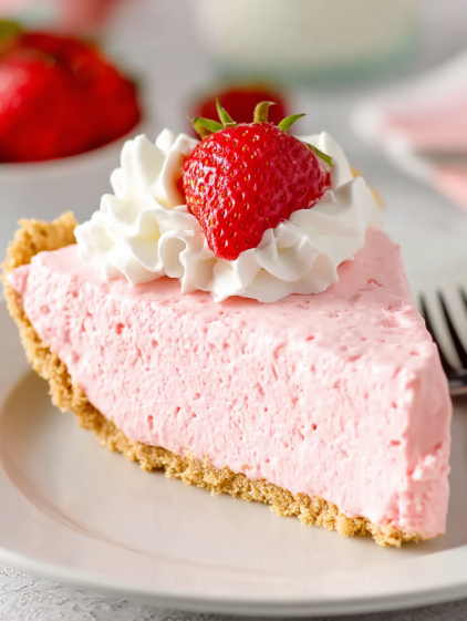 A slice of pink cake with strawberries on top.