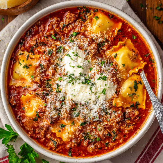 A bowl of pasta with white cheese on top.