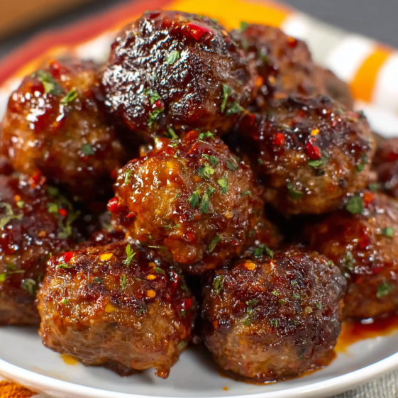 A plate of meatballs with a sauce.