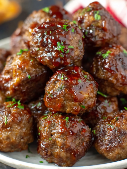 A plate of meatballs with sauce.