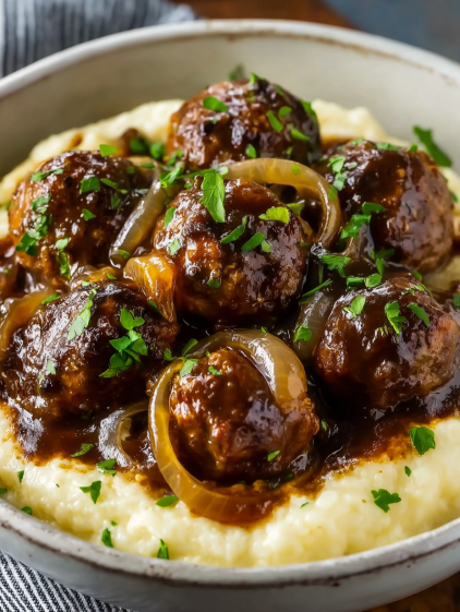 Meatballs in a slow cooker with onions.
