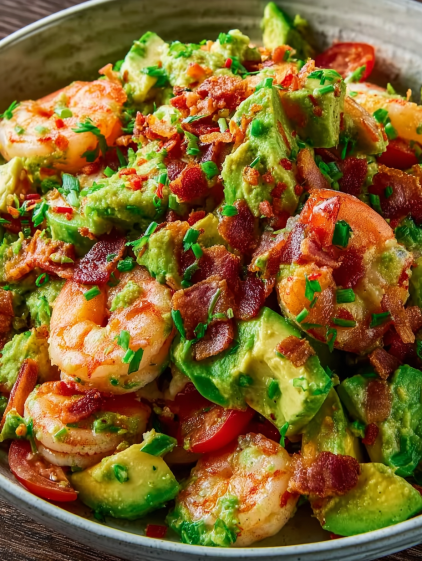 A bowl of shrimp and bacon with avocado.