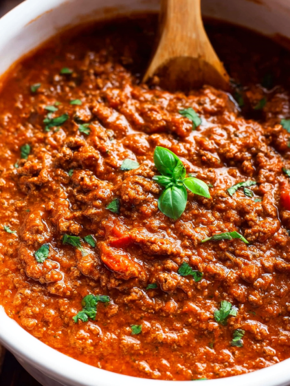 A bowl of chili with a spoon in it.