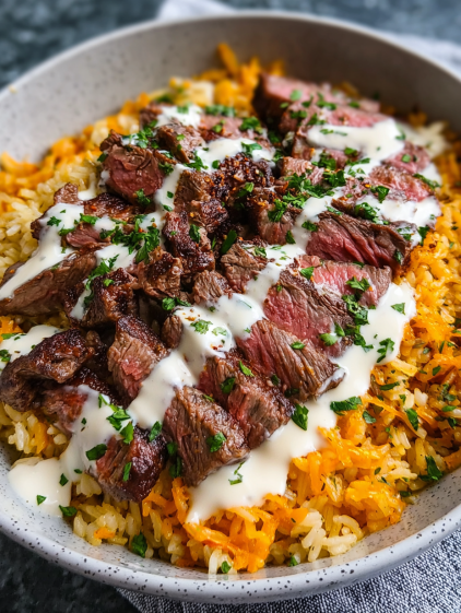 A bowl of rice with steak and cheese.