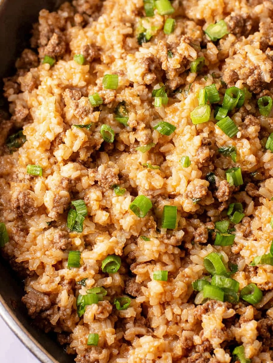A bowl of rice with meat and vegetables.