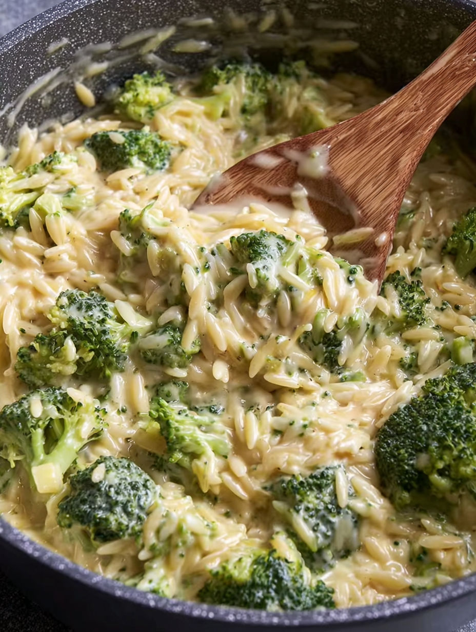 A bowl of pasta with broccoli and cheese.