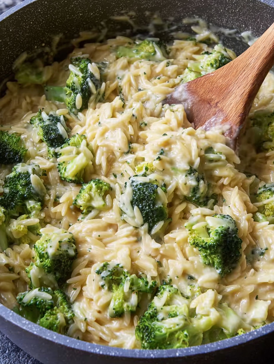 A bowl of pasta with broccoli and cheese.
