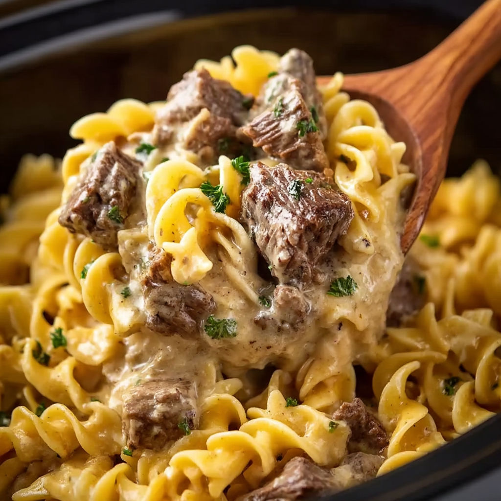 A bowl of beef stroganoff with a wooden spoon.
