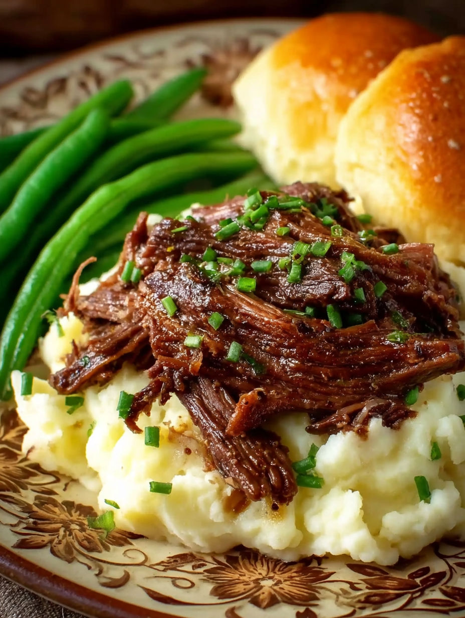 A plate of Mississippi Pot Roast with green beans and biscuits.