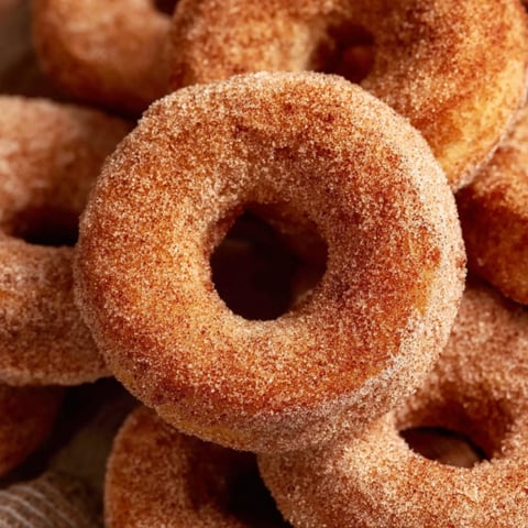 A pile of sugar coated donuts.