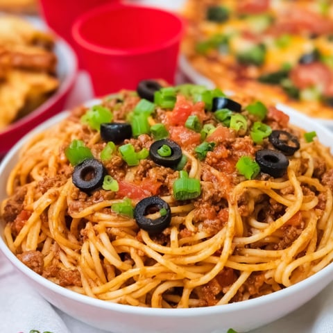 A bowl of spaghetti with meat and vegetables.