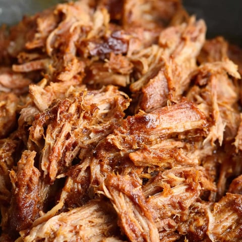 A close up of pulled pork in a pot.
