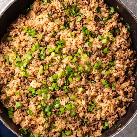 A pan of rice with meat and vegetables.