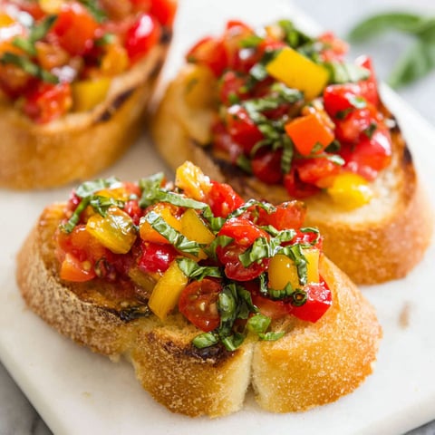 Two pieces of bread with tomatoes and basil on top.