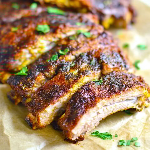 A close up of pork ribs on a grill.