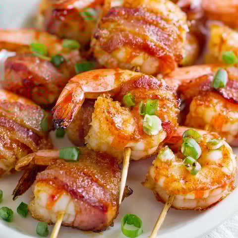 Bacon wrapped shrimp on a plate.