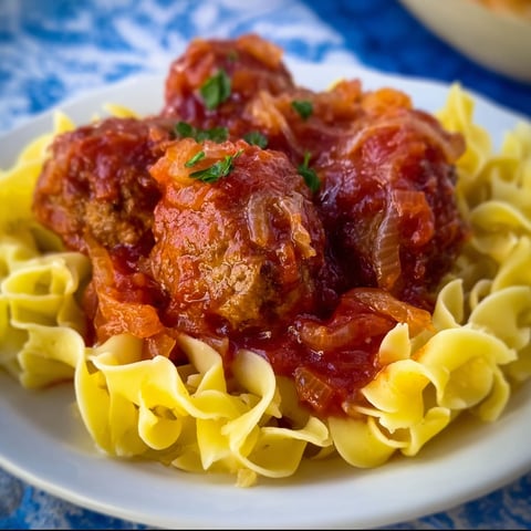 A plate of meatballs covered in sauerkraut.