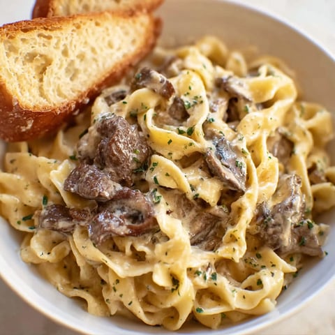 A bowl of pasta with meat and cheese.